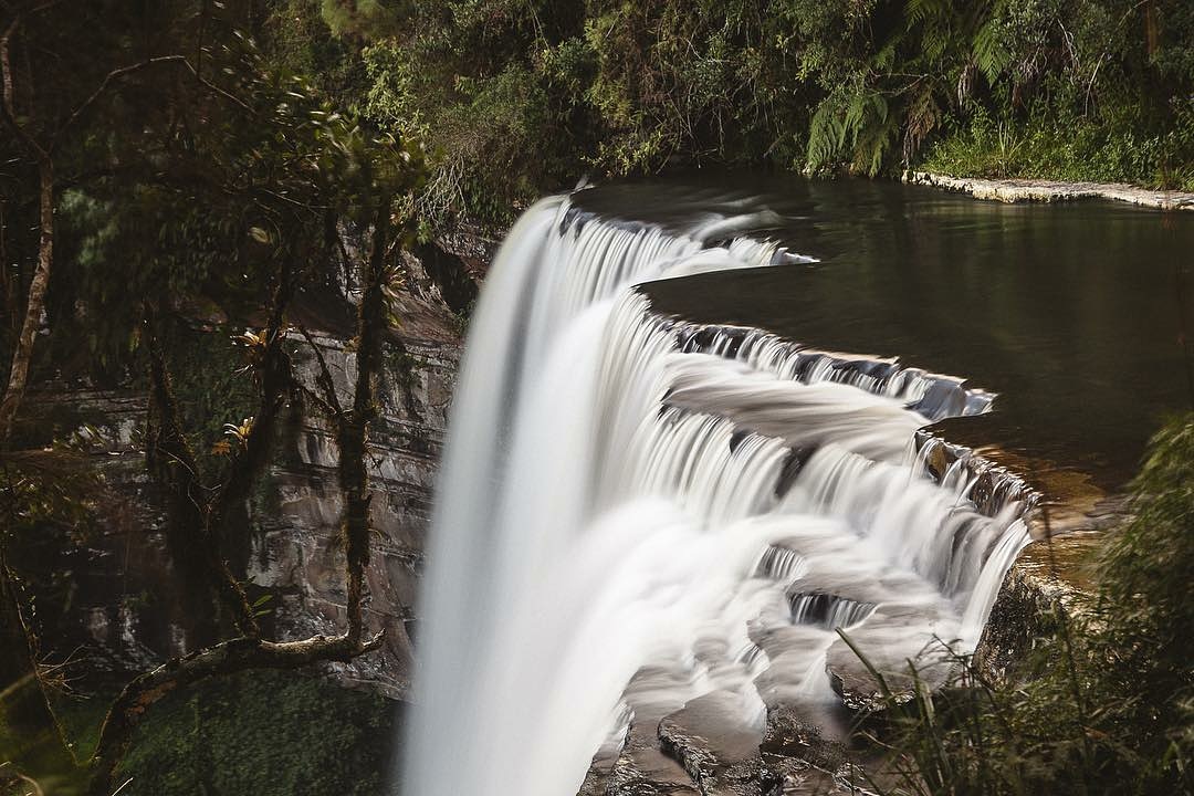 Cachoeira deslizando em lâminas sobre a rocha no meio da floresta